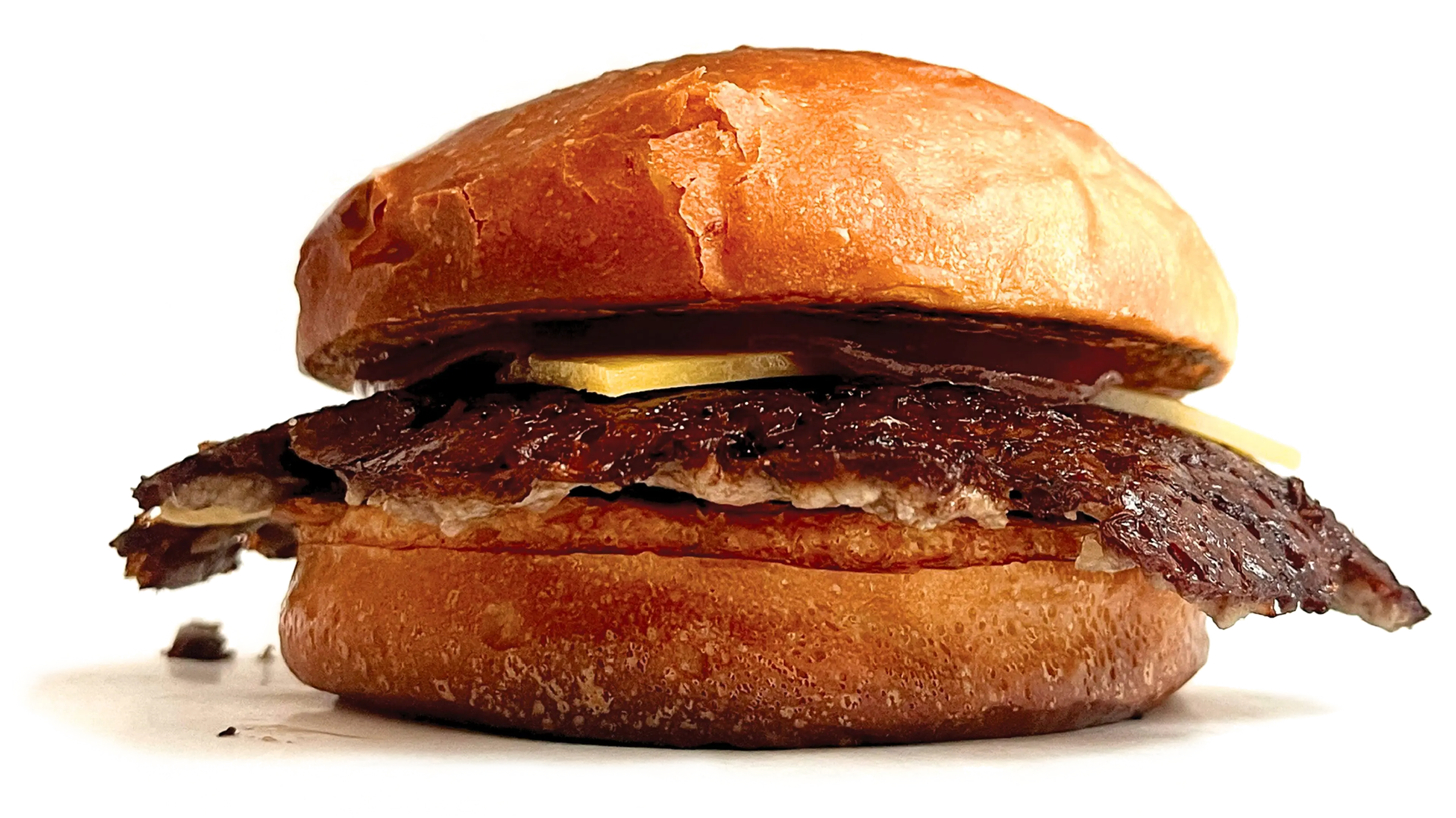 Soczysty smash burger z wołowiną Angus, świeżą sałatą, pomidorem i sosem, podany w domowej bułce - specjalność Zapini w Słupsku